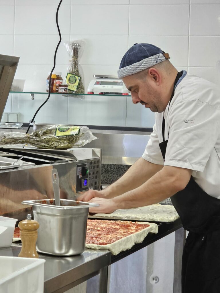 pizzaiolo dans l'ain abaissant la pate de sa pizza